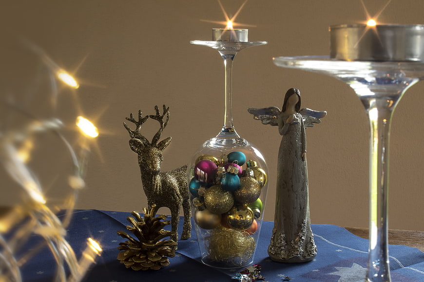 Christmas still life with angel figurine, gold deer, and tea lights