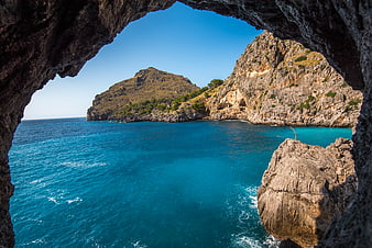 View of Turquoise Sea Through Coastal Cave Arch