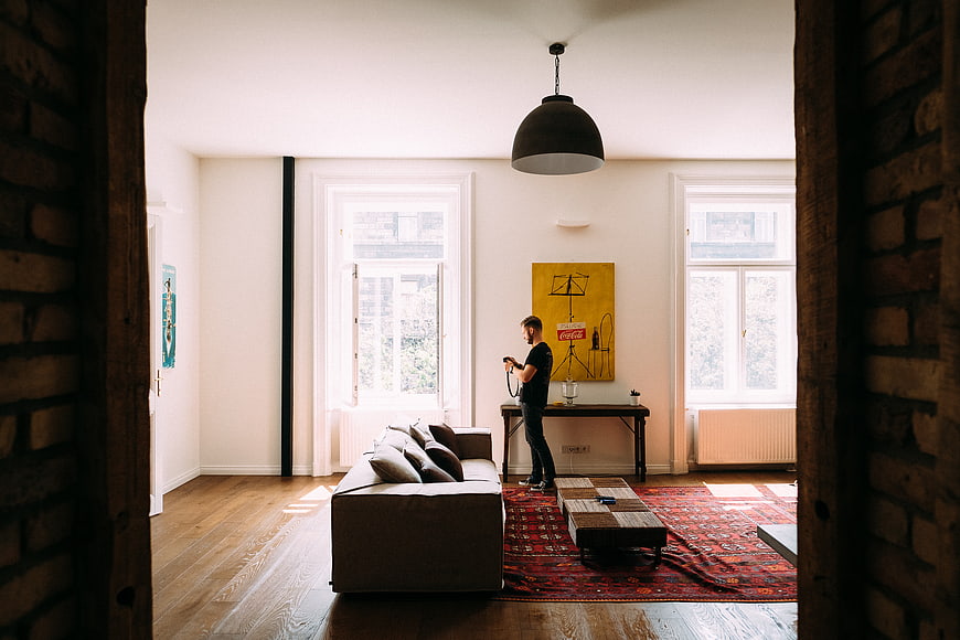 Man standing in modern living room with vintage rug