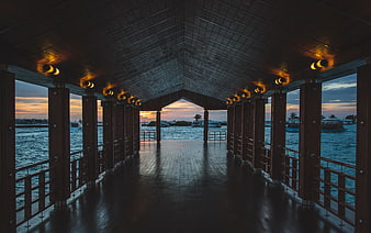 Symmetrical wooden pier walkway at sunset with ocean view