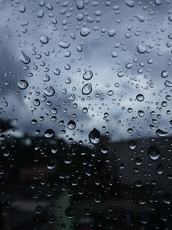 Raindrops on Window Glass with Blurred Background