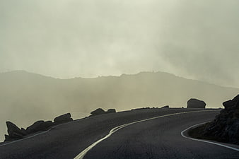 Misty Winding Mountain Road with Foggy Landscape