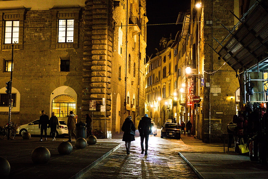 Historic European Street Scene at Night with Pedestrians and Architecture
