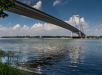 Cable-stayed bridge over river with cargo barge