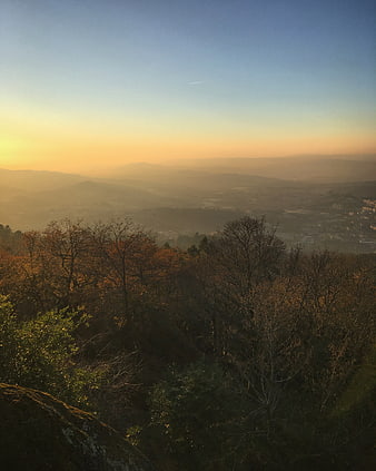 Golden Sunrise Over Hazy Mountain Valley with Forest