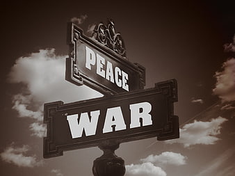 Vintage street sign pointing to peace and war against cloudy sky