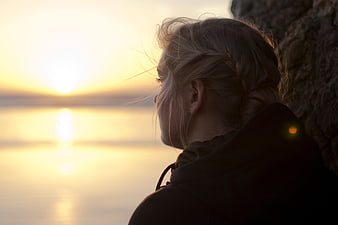 Blonde Woman Silhouette Watching Sunset Over Calm Water