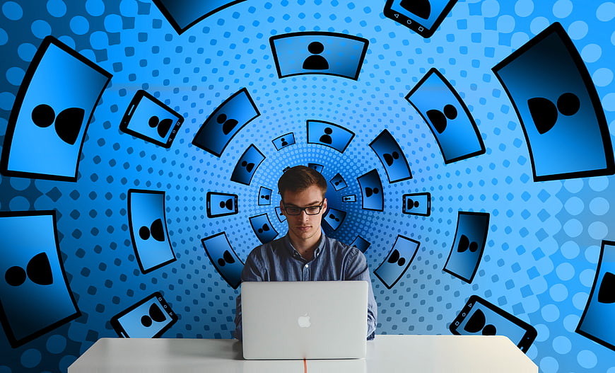 Young man working on laptop with social media icons background