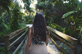Woman Walking Away on Wooden Bridge in Tropical Forest