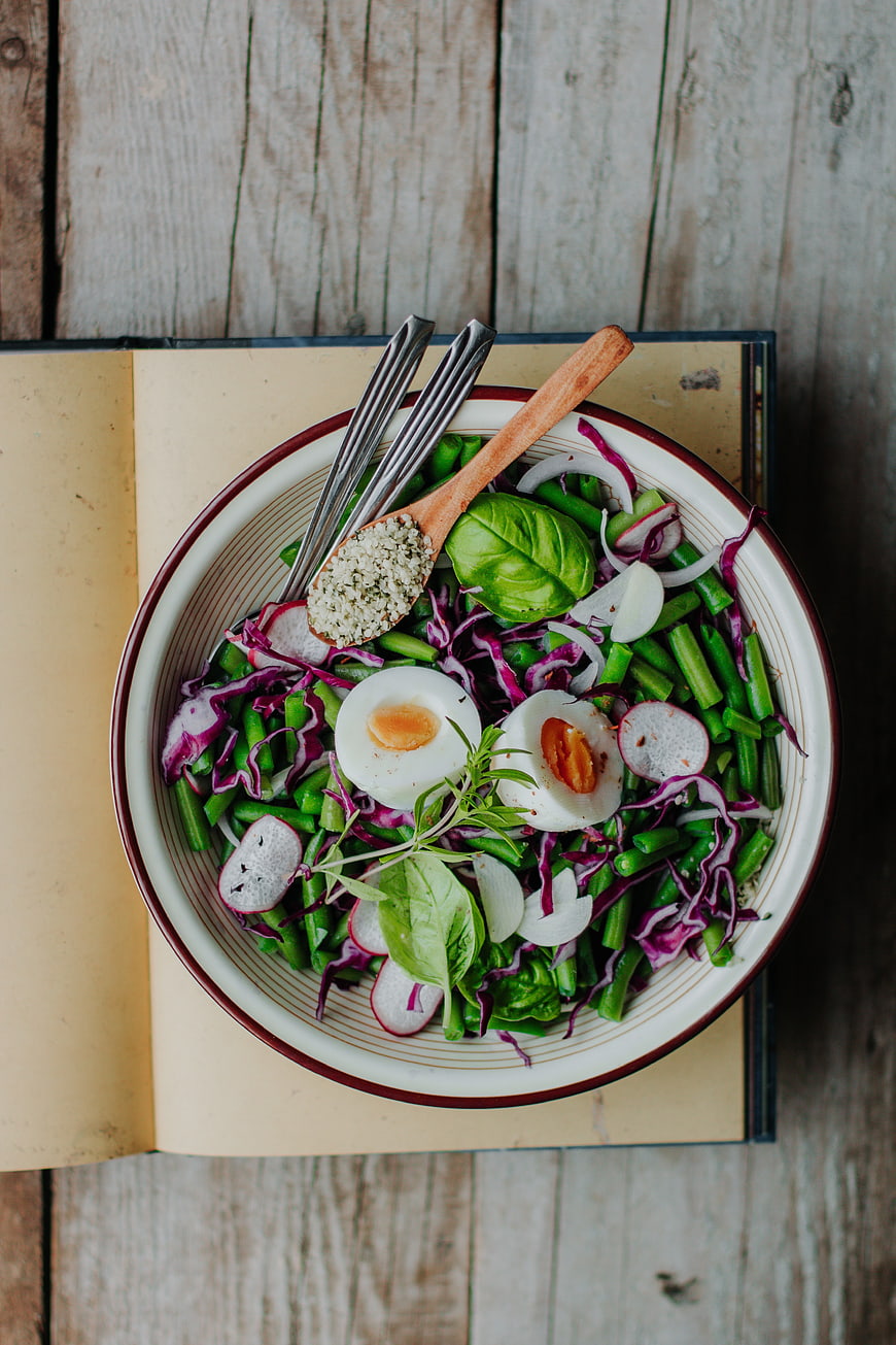 Top view of healthy green bean salad with eggs and hemp seeds