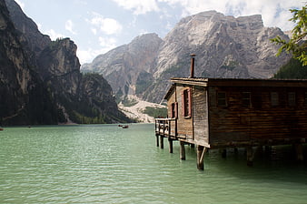 Wooden boathouse on turquoise lake with mountains