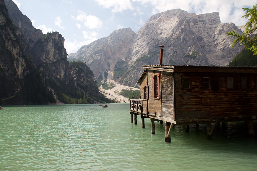 Wooden boathouse on turquoise lake with mountains