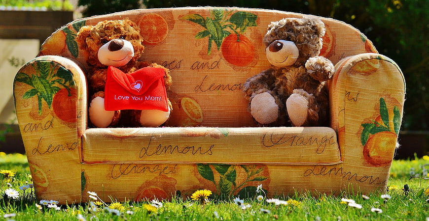 Two teddy bears on citrus print sofa with Mother's Day gift