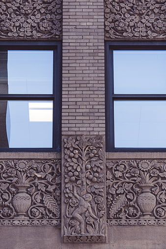 Ornate Stone Carvings on Brick Building Facade