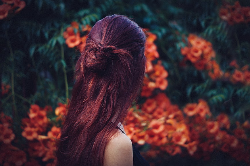 Woman with Red Hair Back View in Orange Flower Garden