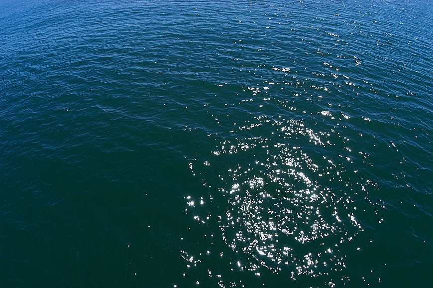 Sparkling Sunlight on Deep Blue Ocean Water Surface