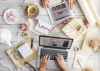 Flat lay of online shopping workspace with laptop and gifts