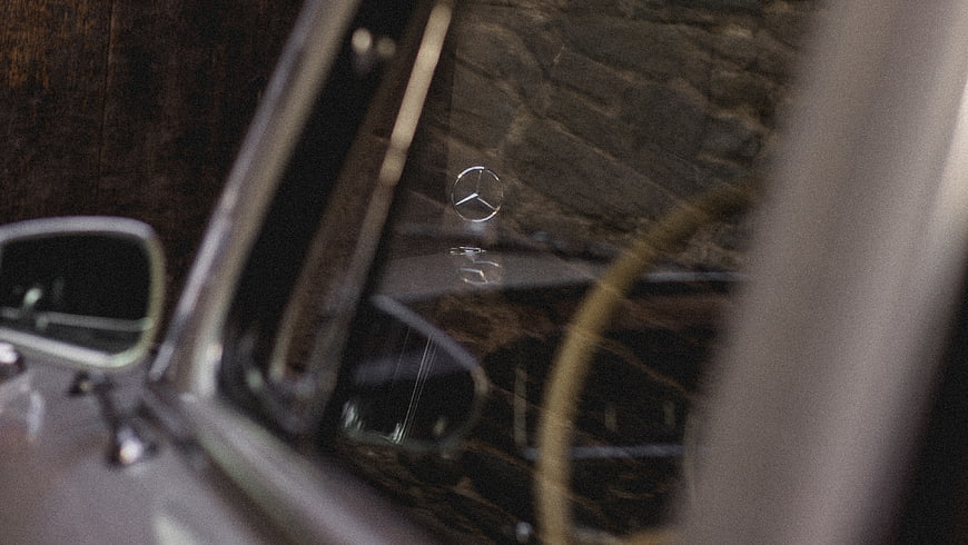 Close-up of vintage Mercedes-Benz hood ornament and side mirror