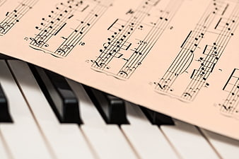 Sheet Music on Piano Keys Close Up