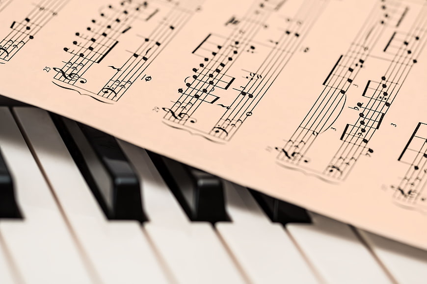 Sheet Music on Piano Keys Close Up