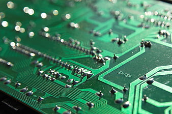 Macro shot of green circuit board with solder points