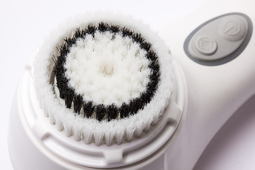 Close-up of white electric facial cleansing brush head