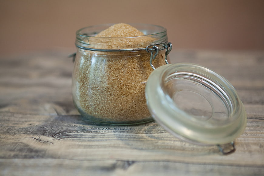 Glass jar of brown sugar on rustic wooden table