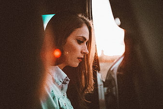 Contemplative Woman in Car at Sunset