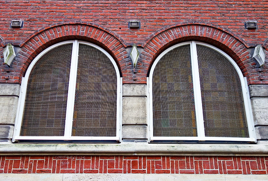Red brick facade with arched windows and white frames