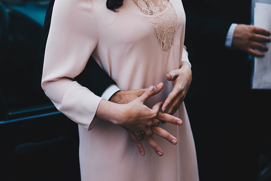Close-up of couple holding hands with wedding ring