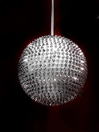 Silver Spiked Christmas Ornament Hanging Against Dark Background