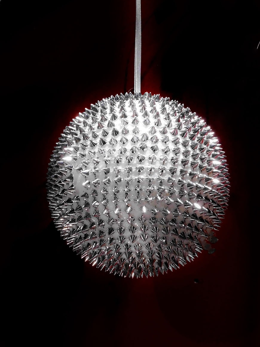 Silver Spiked Christmas Ornament Hanging Against Dark Background