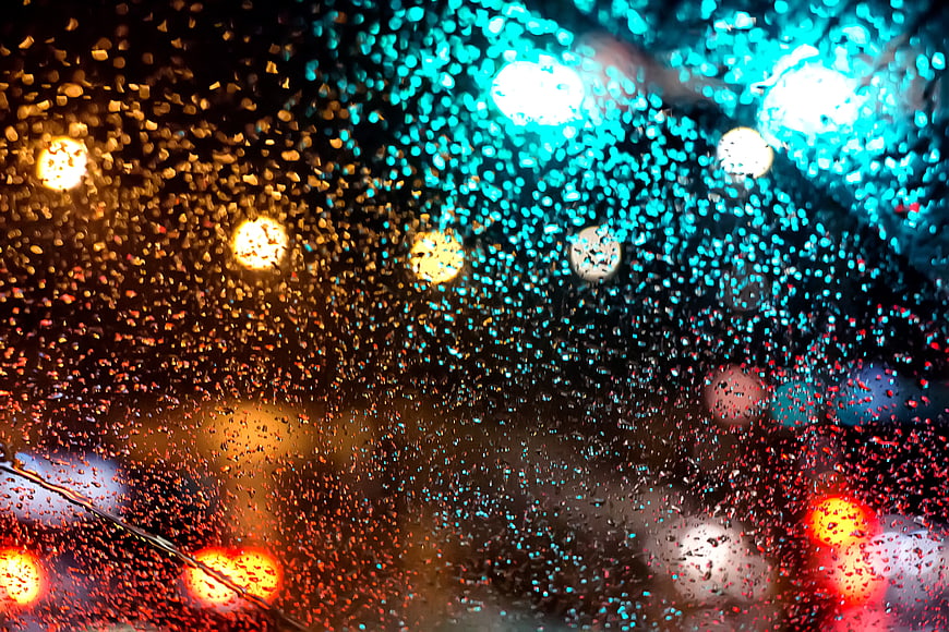 Raindrops on Car Window with City Bokeh Lights