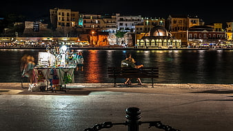 Couple sitting on bench at night waterfront cityscape