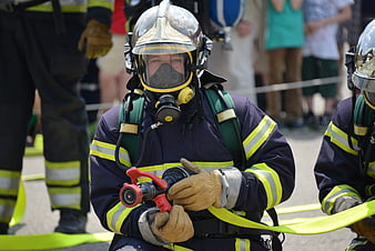 Firefighter in protective gear holding hose nozzle