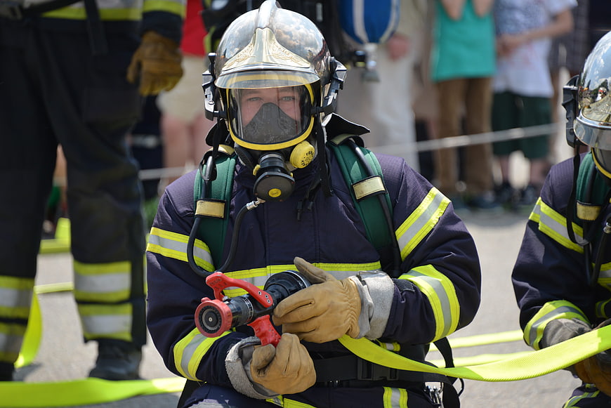 Firefighter in protective gear holding hose nozzle
