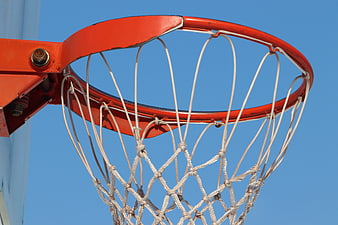 Close-up of red basketball hoop and white net against clear blue sky