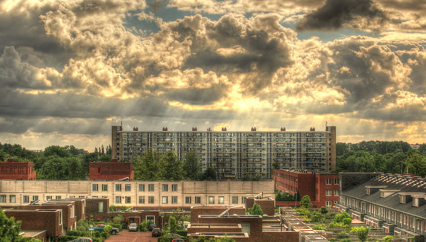 Dramatic HDR cityscape with sunbeams over urban buildings