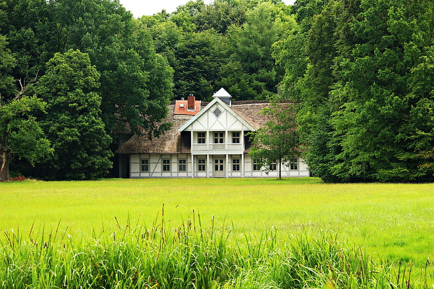 Traditional White House with Thatched Roof in Green Meadow