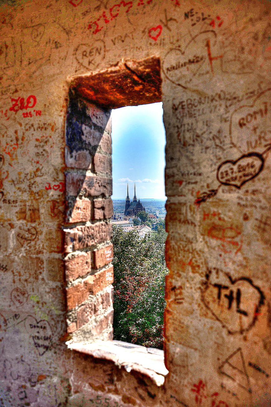View of Cathedral Through Graffiti-Covered Brick Window