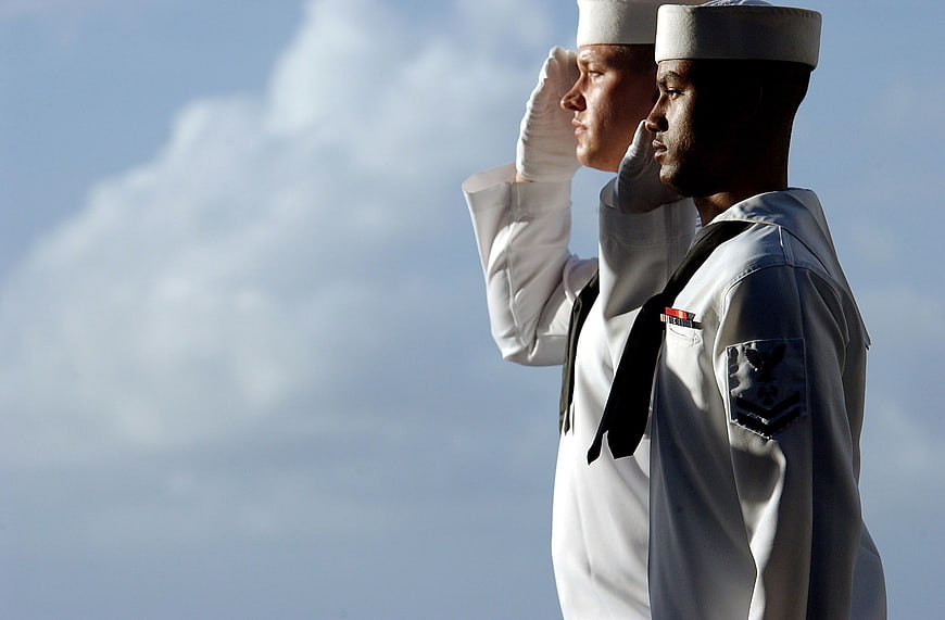 Two Navy Sailors Saluting Against Blue Sky