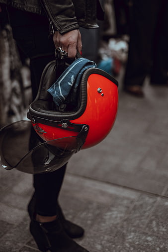 Woman holding red motorcycle helmet with scarf