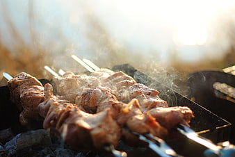 Close-up of Grilled Meat Skewers Smoking on BBQ Grill