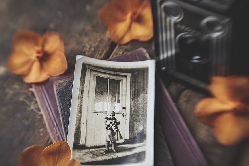 Vintage photograph of child with old camera and dried flowers
