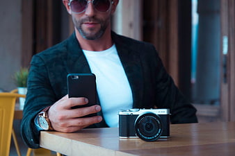 Stylish Man with Smartphone and Camera at Cafe