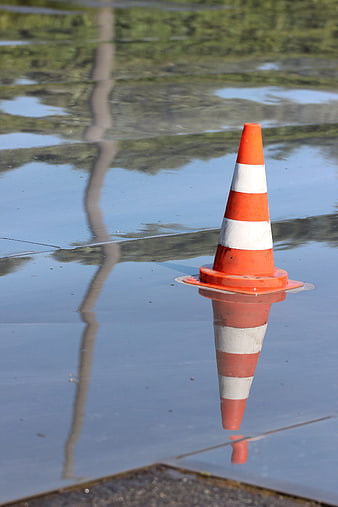 Orange Traffic Cone Floating in Flooded Street Water