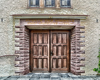 Historic Church Entrance With Carved Stone Inscription And Wooden Doors