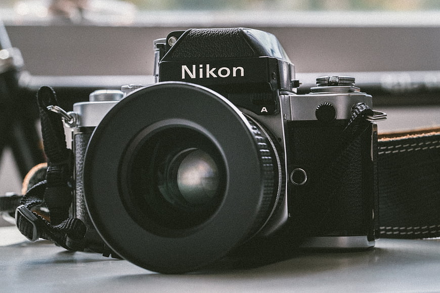 Vintage Nikon Film Camera with Lens Hood on Table