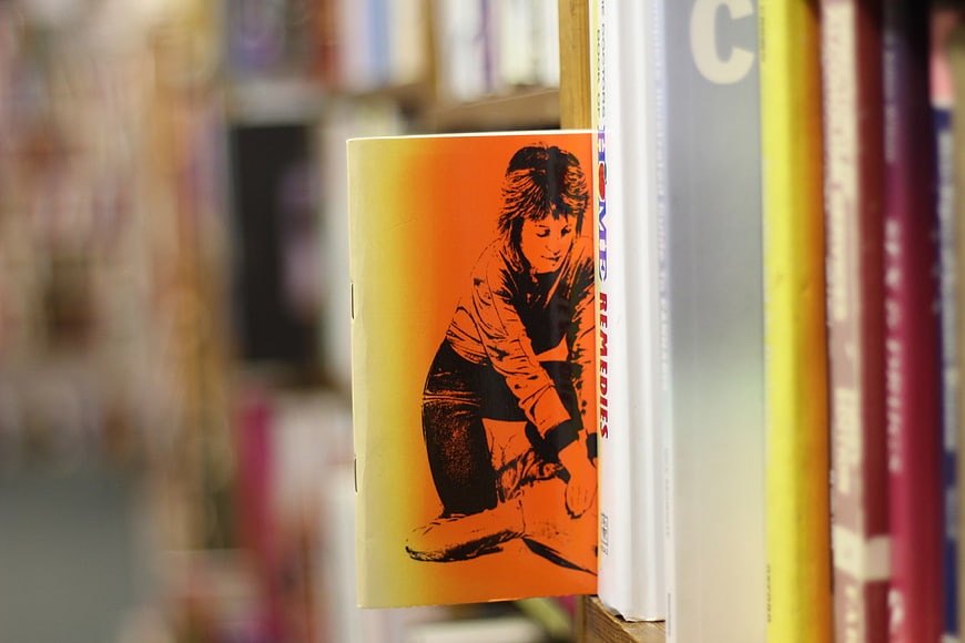 Orange Book Cover on Wooden Shelf in Library