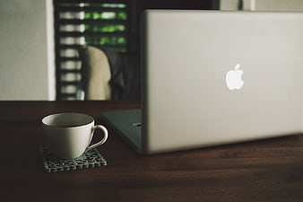 Silver Laptop and Coffee Cup on Wooden Desk